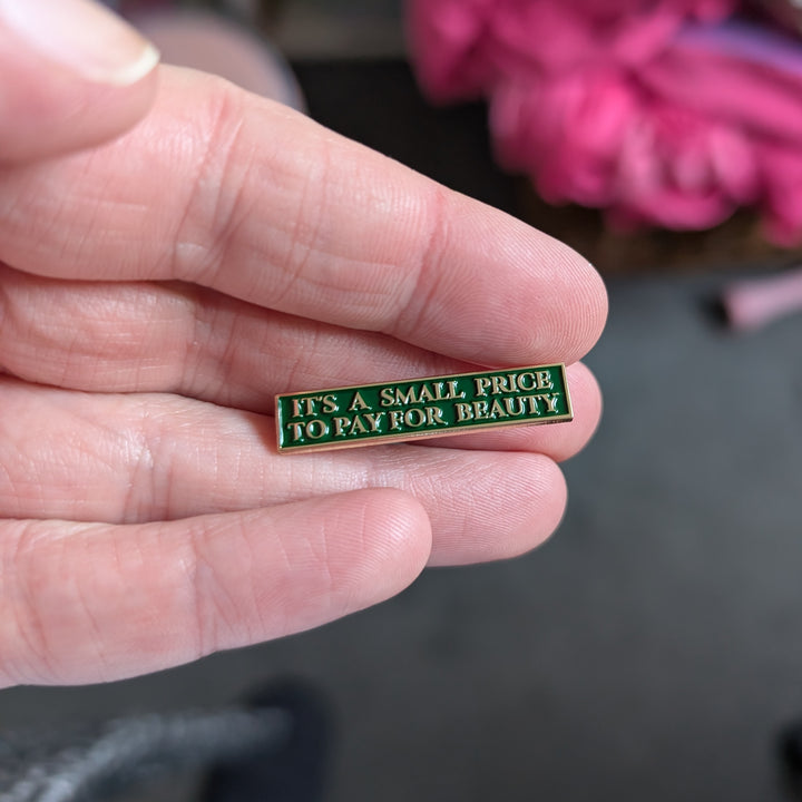 Butch Cassidy and the Sundance Kid Enamel Pin “It’s a Small Price for Beauty” in hand
