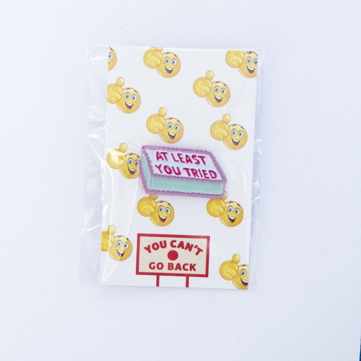 A novelty enamel lapel pin shaped like a motel sign with the text &